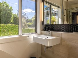 A bathroom with a sink and mirror at Moa Magic - Oneroa Holiday Home Oneroa