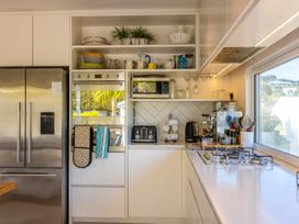 A kitchen with a refrigerator, oven, and countertop appliances at Moa Magic - Oneroa Holiday Home Oneroa