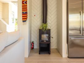 A living room with a fireplace and refrigerator at Moa Magic - Oneroa Holiday Home Oneroa