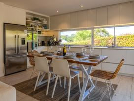 A kitchen with a dining area featuring a table and chairs at Moa Magic - Oneroa Holiday Home Oneroa