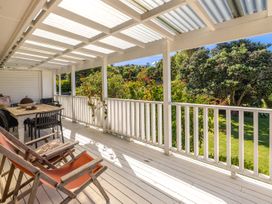 An outdoor deck with a table and chairs at Moa Magic - Oneroa Holiday Home Oneroa