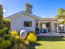 A house with a deck and garden at Moa Magic - Oneroa Holiday Home Oneroa