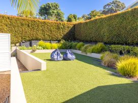 A garden with bean bags and artificial grass at Moa Magic - Oneroa Holiday Home Oneroa