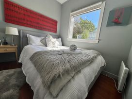 A bedroom with a bed and bedside table at Stag & 3 Pigs - Ohakune