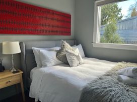 A bedroom with a bed and lamp at Stag & 3 Pigs - Ohakune Holiday Home Ohakune