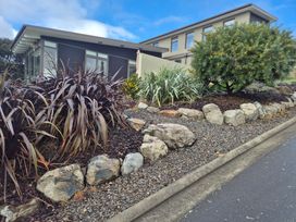 A landscaped garden with rocks and plants at Kotare Point Paradise - Akaroa