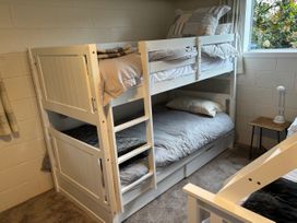 A bunk bed with bedding and a nightstand at Kuratau Classic - Kuratau Holiday Home Kuratau
