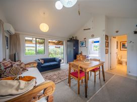 A living room with a sofa and dining table at Beech Retreat - Te Anau Holiday Home in Te Anau