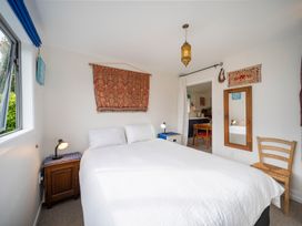 A bedroom with a bed and mirror at Beech Retreat - Te Anau Holiday Home in Te Anau