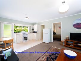 A kitchen with appliances and furniture at Downstairs one Bedroom Apartment in Paihia