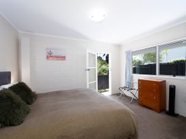 A bedroom with a bed and chest of drawers at Camellia with WiFi - Paihia