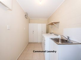 A laundry room with a washing machine and sink at Camellia with WiFi - Paihia