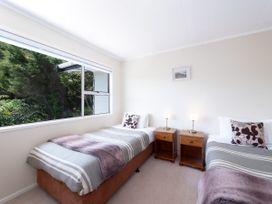 A bedroom with two beds and a window at Rimu - Paihia Holiday Home, Paihia