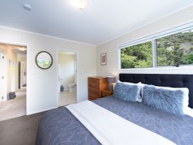 A bedroom with a bed and dresser at Rimu - Paihia Holiday Home, Paihia
