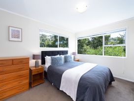 A bedroom with a bed and dresser at Rimu - Paihia Holiday Home in Paihia