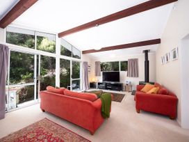 A living room with a sofa and television at Rimu - Paihia Holiday Home, Paihia