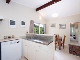 A kitchen with a sink and dining area at Rimu - Paihia Holiday Home Paihia