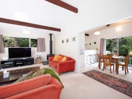 A living room with a television and sofa at Rimu - Paihia Holiday Home in Paihia