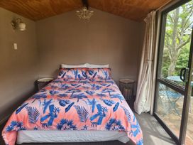 A bedroom with a bed and bedside tables at The Willow - Hanmer Springs Holiday Home