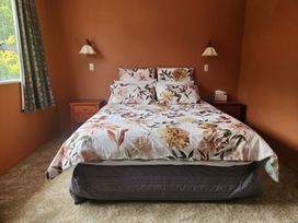 A bedroom with a bed and nightstand at The Willow - Hanmer Springs Holiday Home