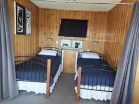 A bedroom with two beds and a nightstand at Kenshaw Cottage - Omori Bach, Omori