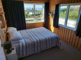 A bedroom with a bed and windows at Kenshaw Cottage - Omori Bach, Omori