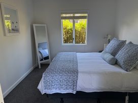 A bedroom with a bed and a mirror at Mahuta Maison - Lake Taupo Holiday Home Five Mile Bay