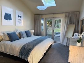 A bedroom with a bed and dresser at Mahuta Maison - Lake Taupo Holiday Home Five Mile Bay
