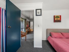 A bedroom with a bed and a chair at Riverbed Lodge - Lake Taupo Home Tauranga Taupo