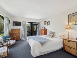 A bedroom with a bed and television at Riverbed Lodge - Lake Taupo Home, Tauranga Taupo