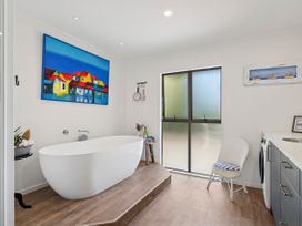 A bathroom with a bathtub and window at Riverbed Lodge - Lake Taupo Home in Tauranga Taupo