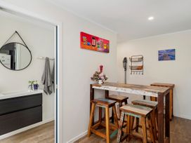 A kitchen with a table and stools at Riverbed Lodge - Lake Taupo Home Tauranga Taupo