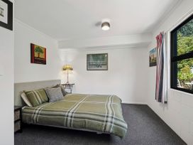 A bedroom with a bed and lamp at Riverbed Lodge - Lake Taupo Home Tauranga Taupo