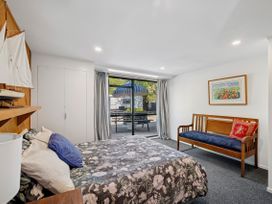 A bedroom with a bed and a seating area at Riverbed Lodge - Lake Taupo Home Tauranga Taupo