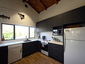A kitchen with appliances and cabinets at Riverbed Lodge - Lake Taupo Home Tauranga Taupo