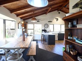 A kitchen with dining area and bar stool at Riverbed Lodge - Lake Taupo Home Tauranga Taupo