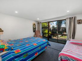 A bedroom with two beds and a wide window at Riverbed Lodge - Lake Taupo Home Tauranga Taupo