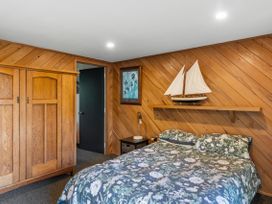 A bedroom with a bed and wardrobe at Riverbed Lodge - Lake Taupo Home Tauranga Taupo