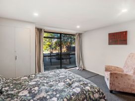 A bedroom with a bed and curtains at Riverbed Lodge - Lake Taupo Home Tauranga Taupo