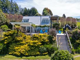 An outdoor view of a house with a garden and deck at Pukawa Country Lodge - Pukawa Bay