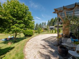 A garden with trees, bushes, and a gravel path at Pukawa Country Lodge - Pukawa Bay