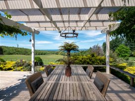 An outdoor dining area with a table and chairs at Pukawa Country Lodge - Pukawa Bay
