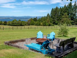An outdoor seating area with a fire pit and chairs at Pukawa Country Lodge - Pukawa Bay