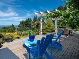 A deck area with blue chairs and table at Pukawa Country Lodge - Pukawa Bay