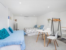 A bedroom with a sofa bed and double bed at Patton's Place - Pauanui Holiday Home, Pauanui