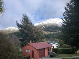 A building with mountains and trees at Korimako Ridge - Lake Hawea Holiday Home Lake Hawea