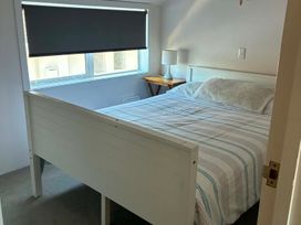 A bedroom with a bed and side table at Fenworth - Taupo Holiday Home in Taupo Central