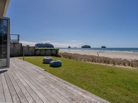 An outdoor space with grass and deck at Beachfront Beauty - Whangamata Beachfront Home Whangamata