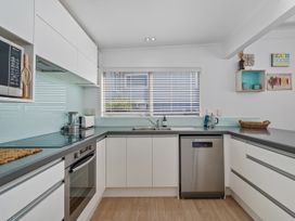 A kitchen with appliances including a microwave and oven at Beachfront Beauty - Whangamata