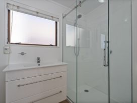 A bathroom with a sink and shower at Beachfront Beauty - Whangamata Beachfront Home Whangamata